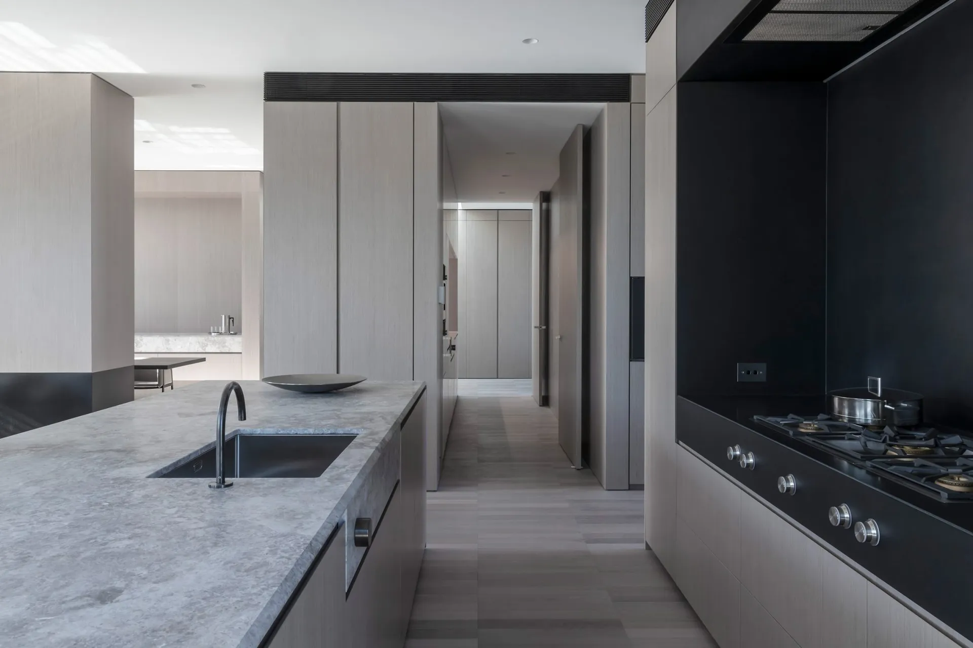 A minimalist kitchen featuring a concrete countertop and wooden cabinets.