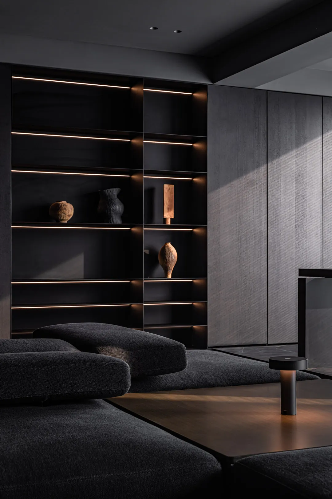 Modern minimalist living room featuring metallic furniture and dark, elegant accessories.