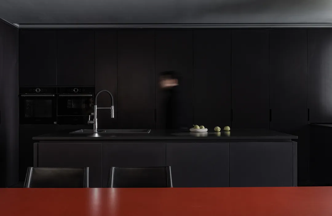Contemporary kitchen with black cabinets and countertops.