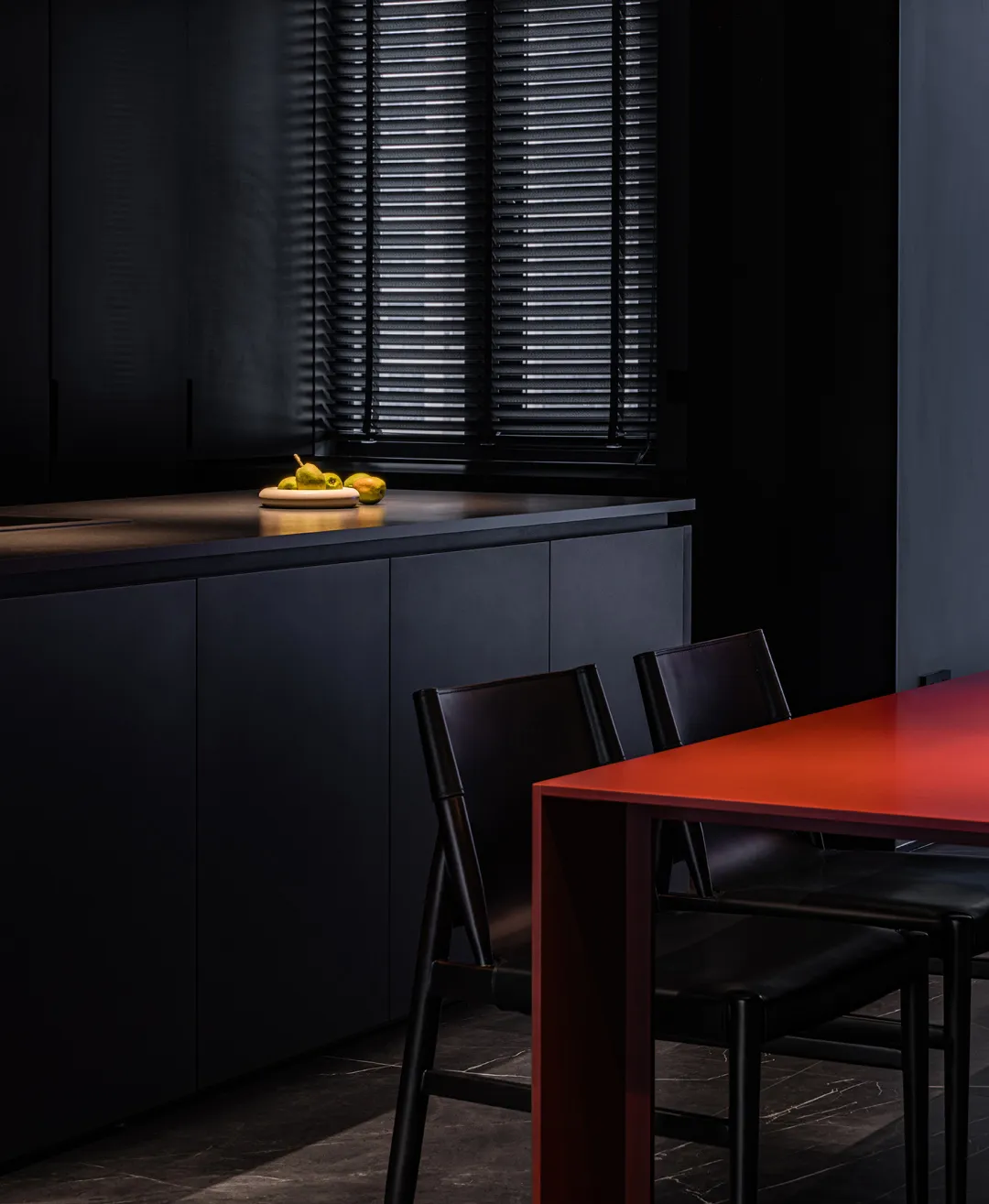 Modern kitchen with black countertops and metal finishes.