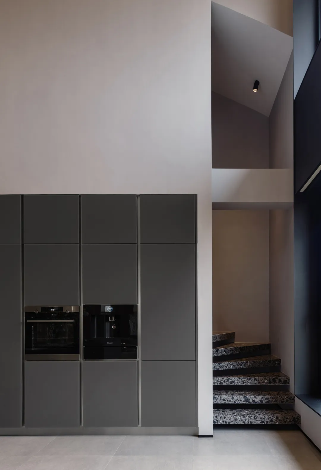 Modern kitchen with sleek gray cabinets and marble counters.