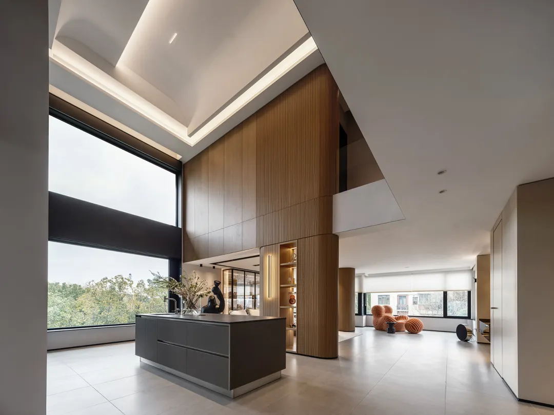 A modern living room with wooden accents, glass walls, and concrete flooring.