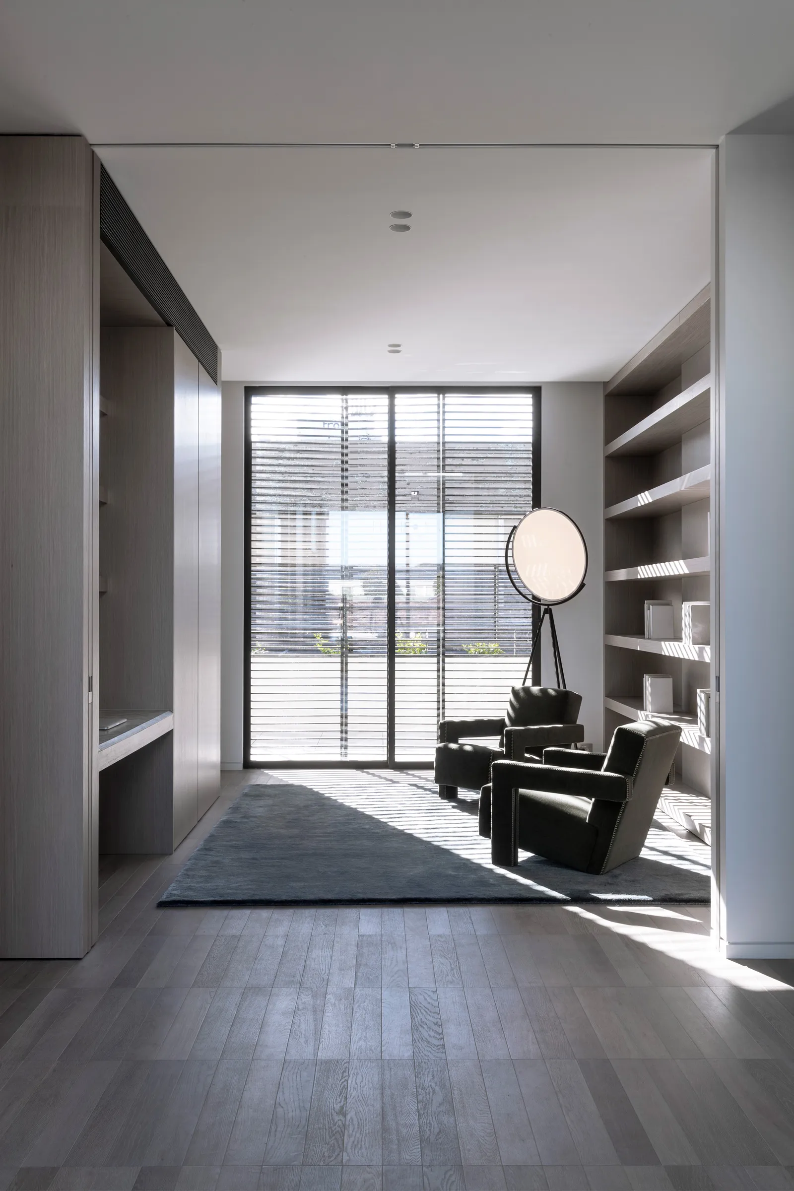 A cozy minimalist living room with wooden flooring and furniture.