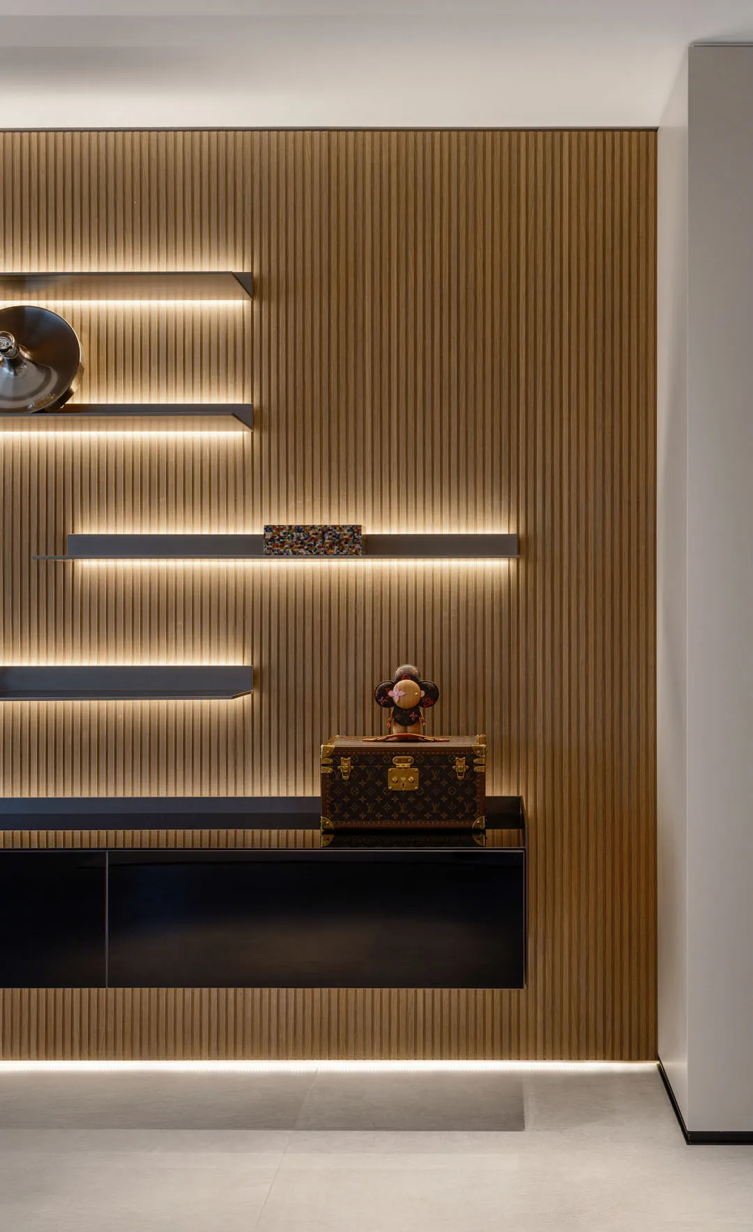 Modern minimalist living room storage unit with horizontal wood panels and integrated lighting.