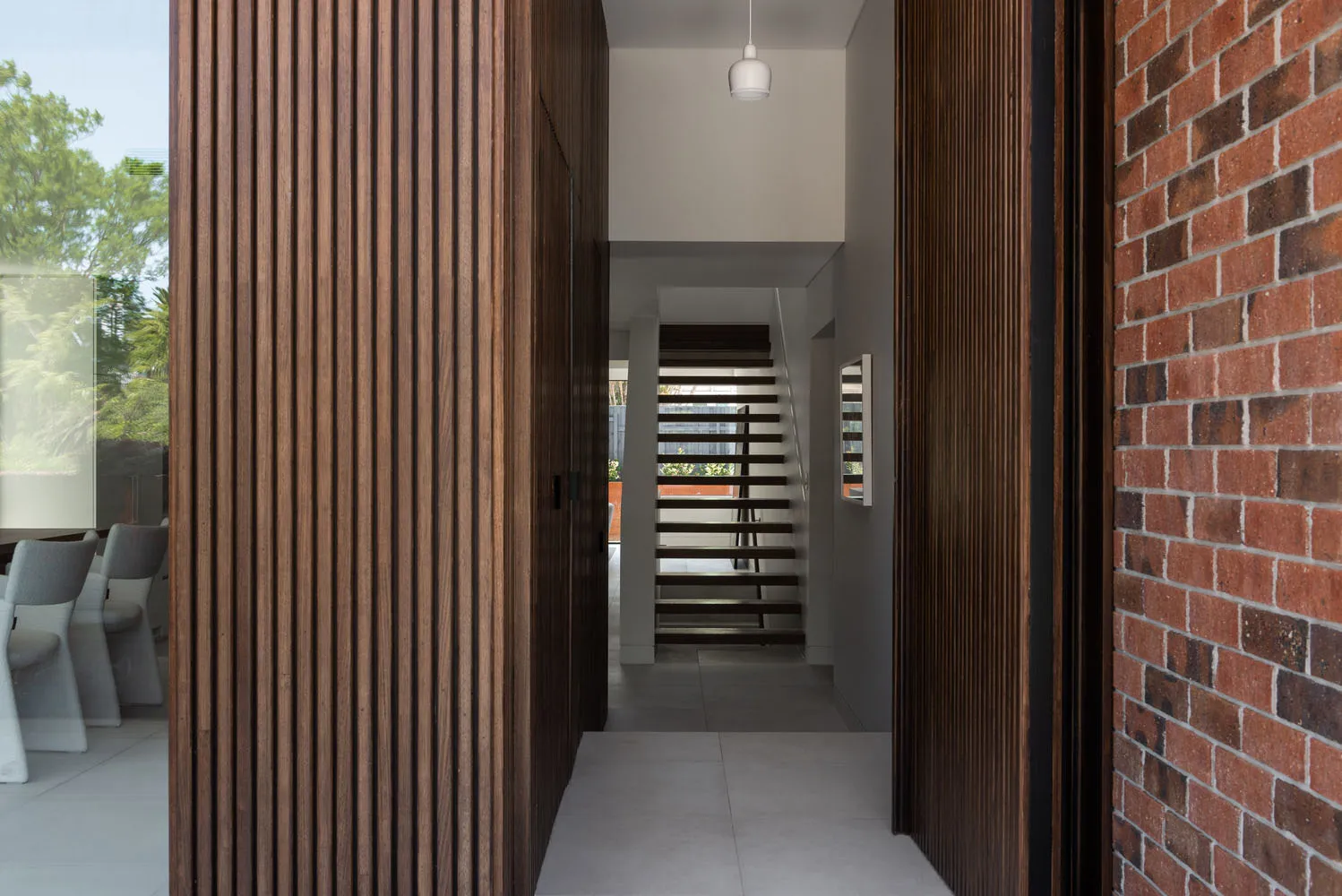 Modern entryway featuring wooden panels and brick walls.