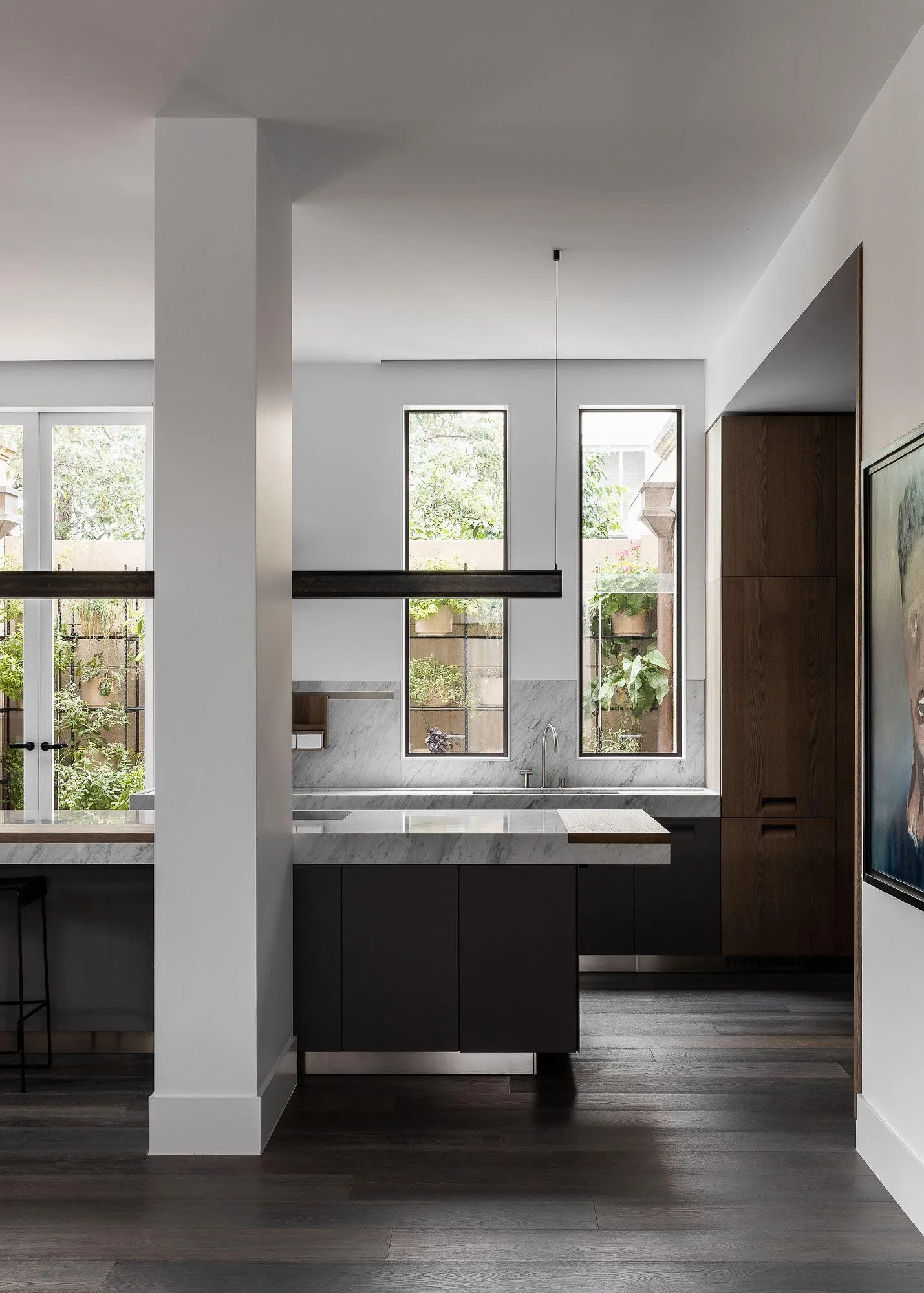 A modern interior space featuring concrete materials and tall windows.