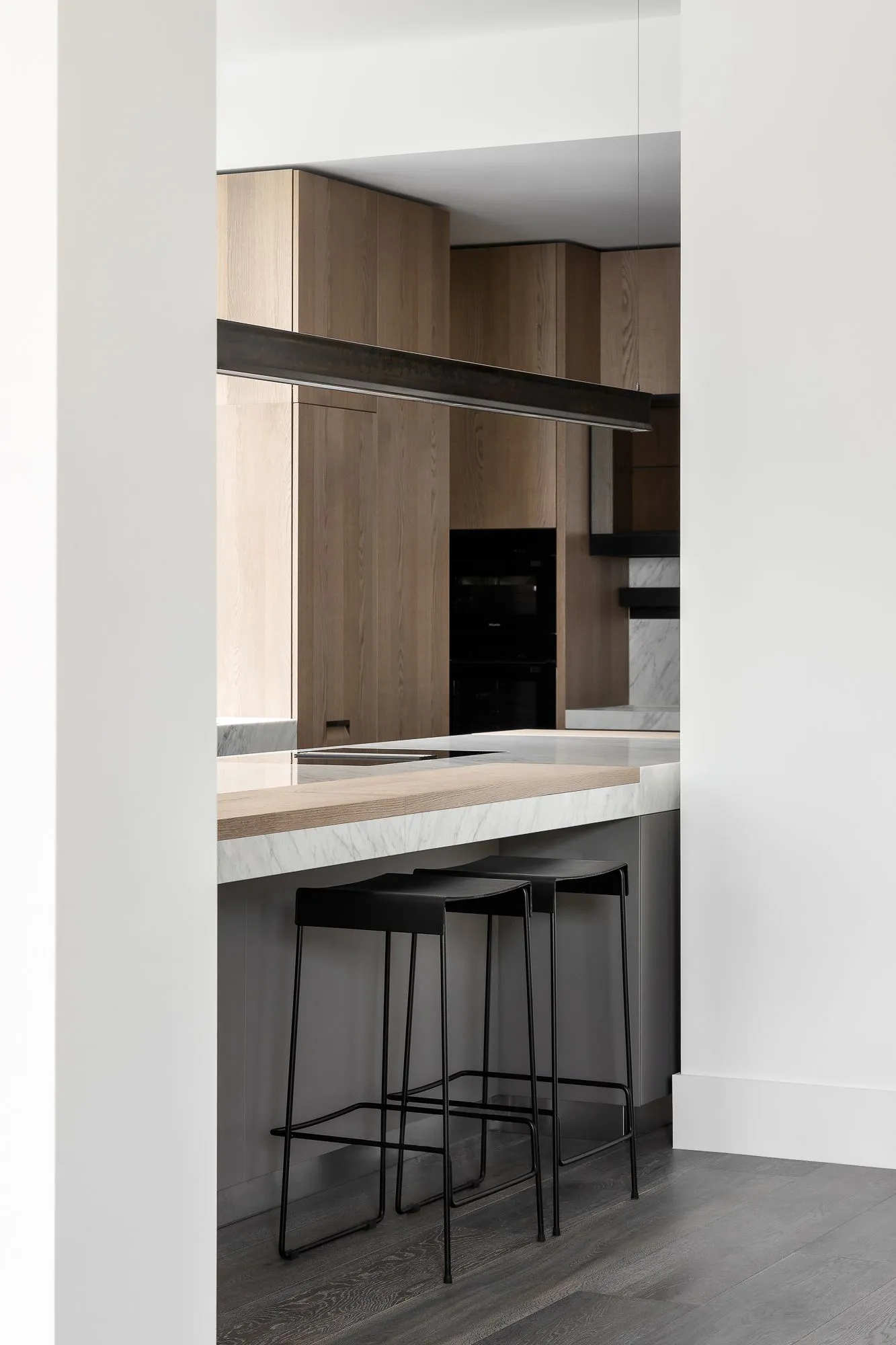 Modern kitchen interior featuring wood and marble materials.