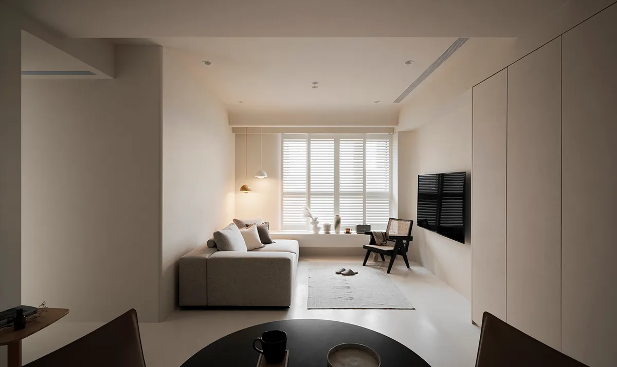 A minimalist living room with neutral-colored furniture and decor.
