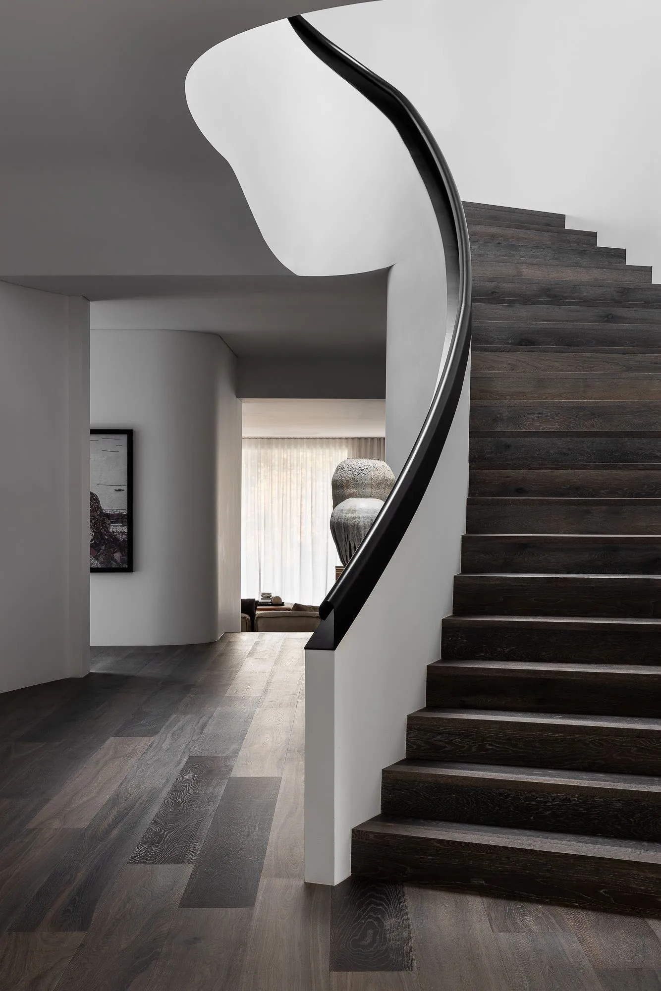 Modern black wood staircase with sleek, curved railings.