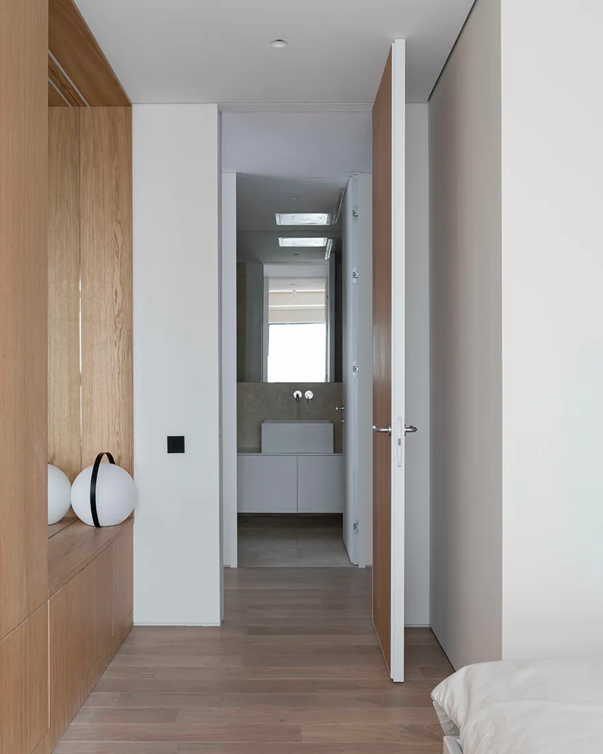 A minimalist bathroom with white lighting and wooden walls and floor.