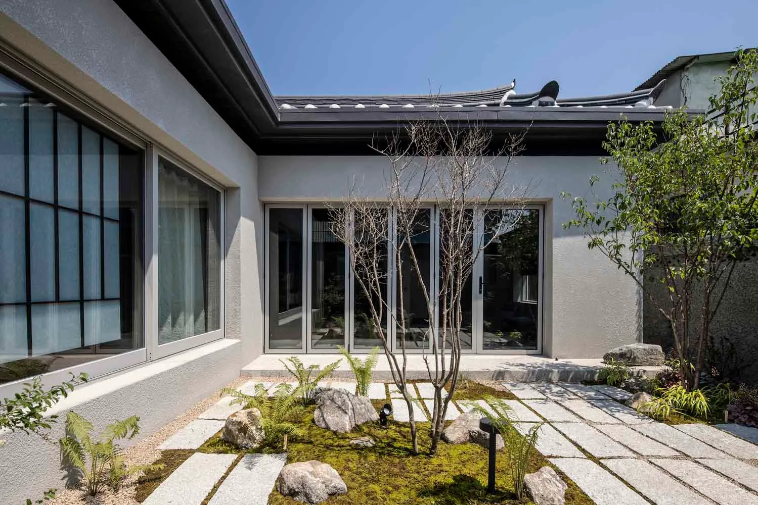 現代簡約住宅外觀，融入混凝土、岩石與植物元素