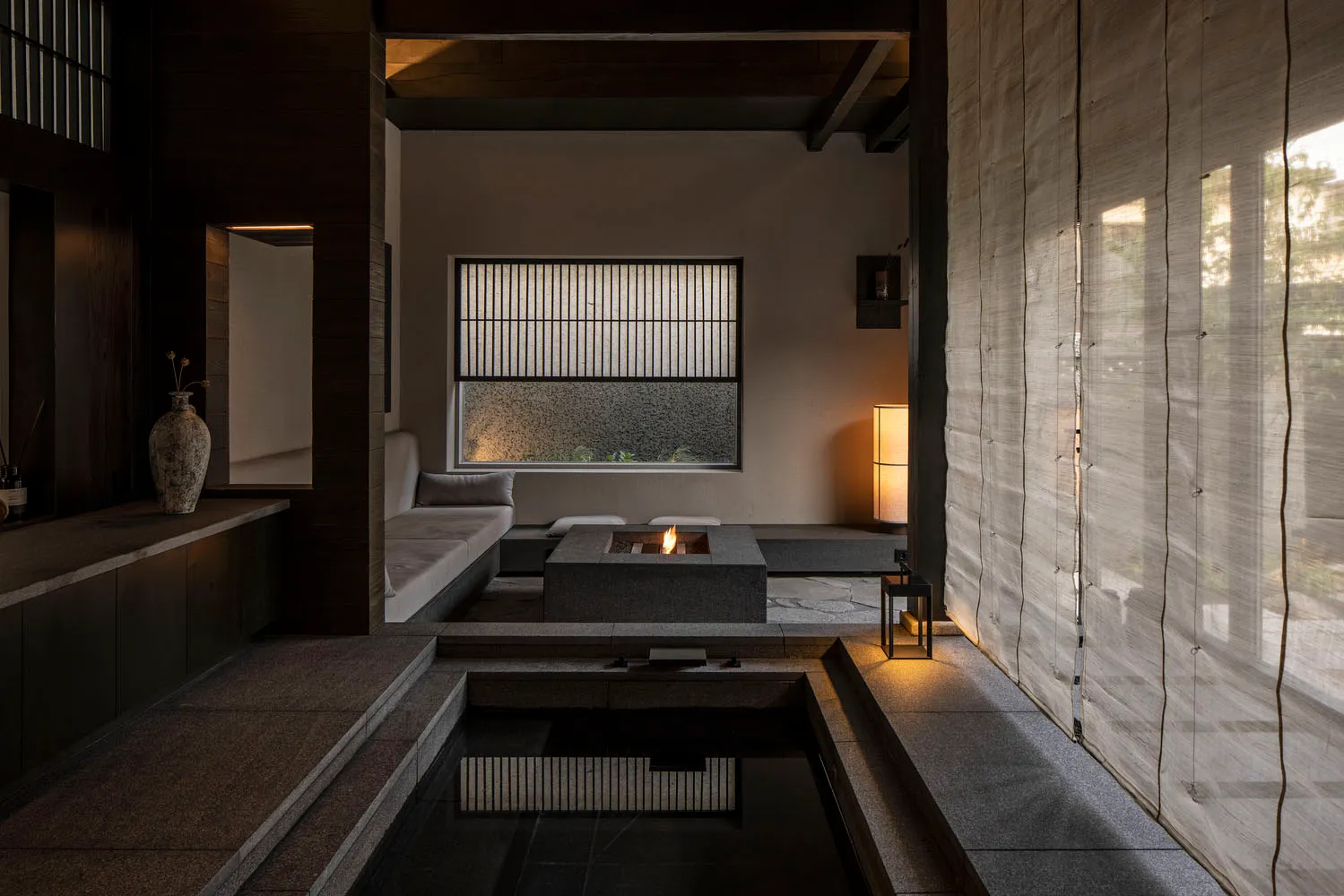 A minimalist living room with a stone fireplace and floor.