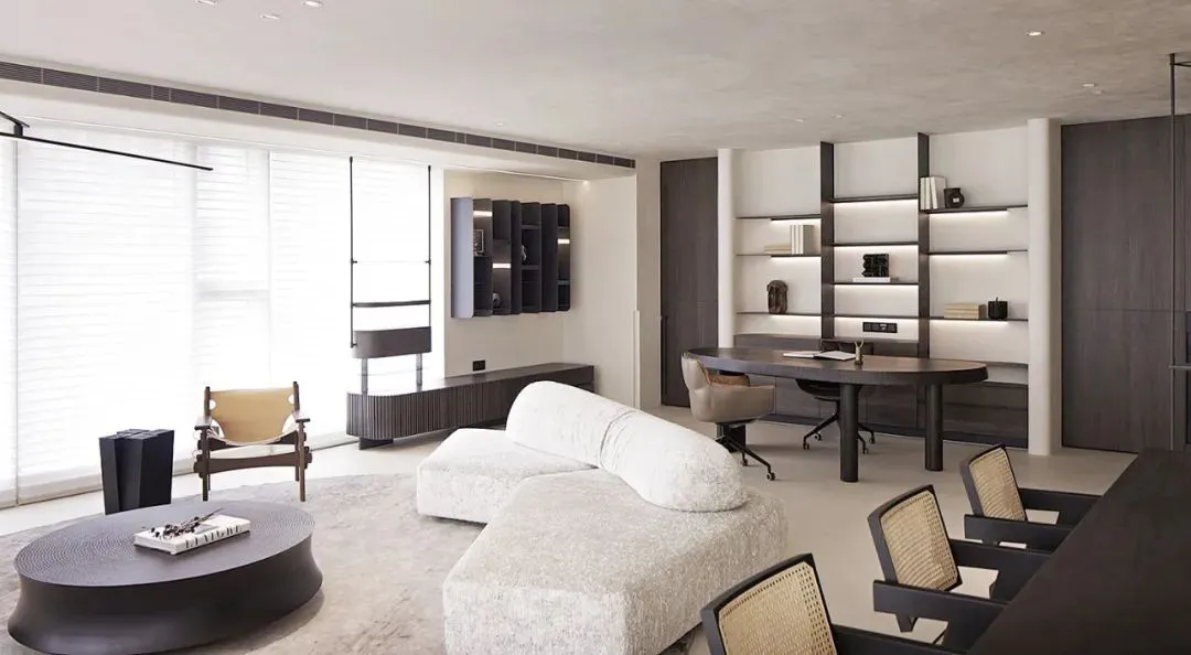 Modern living room and office space with white sofa, dark wood furniture, and open shelving.