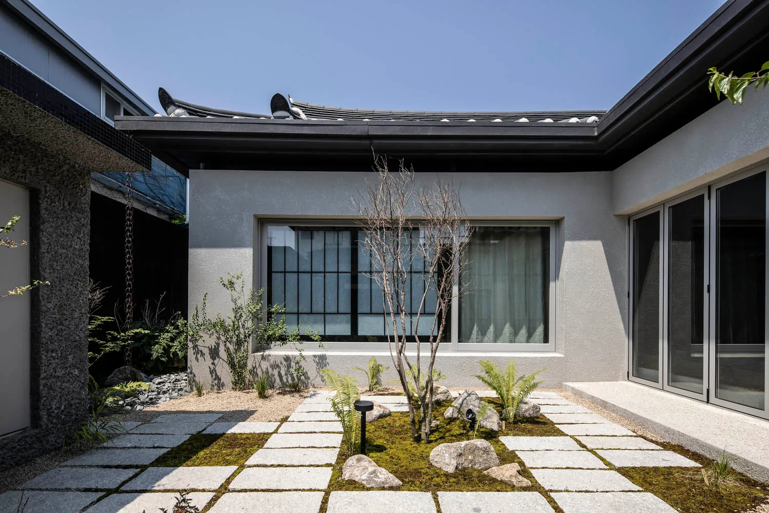 Minimalist residential courtyard featuring modern concrete and glass materials.