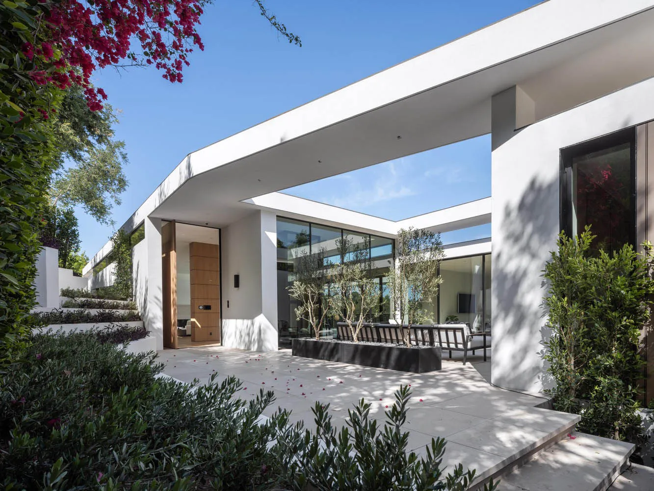A modern house featuring a mix of concrete, glass, and steel materials.
