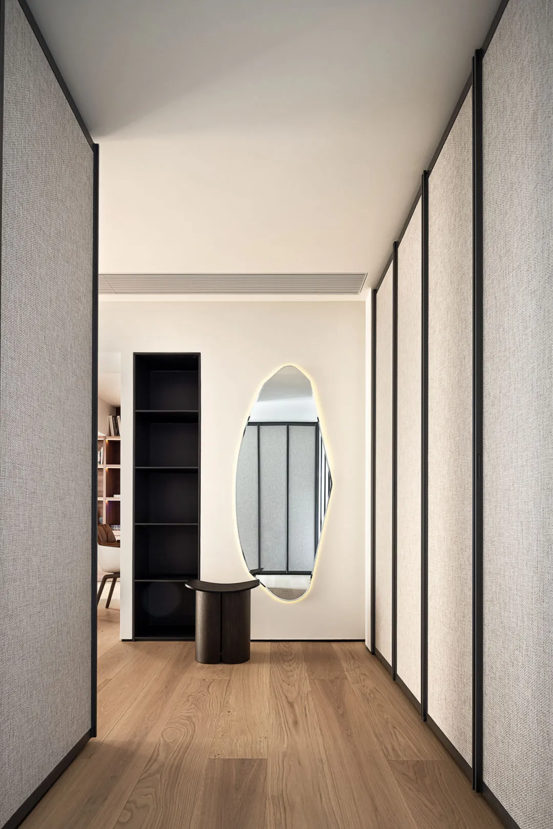 Modern hallway with textured wall panels and hardwood flooring