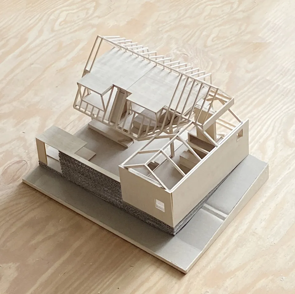 A detailed wooden model of a residential home, showcasing its structure and design.