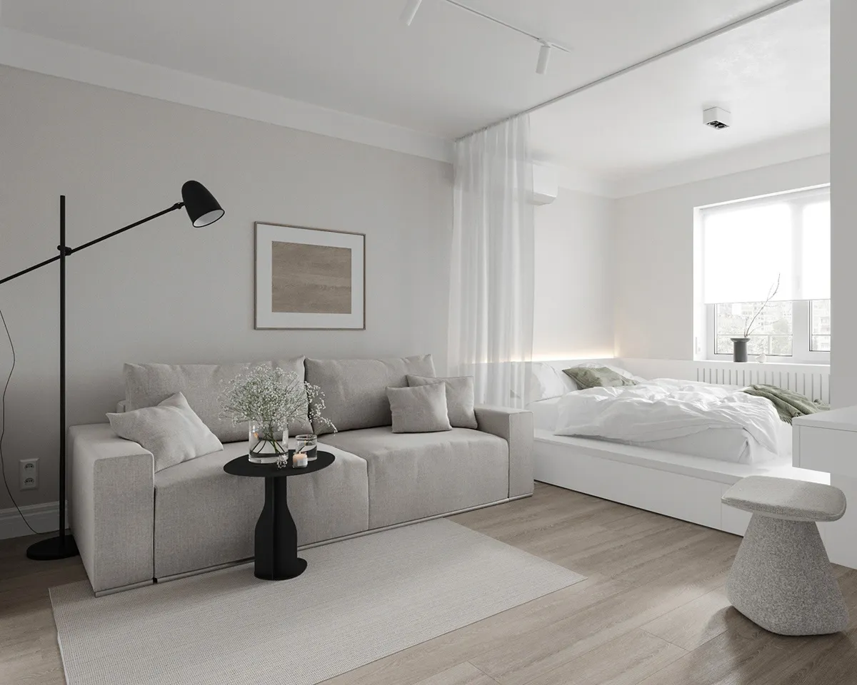 Minimalist living room with a bed in an adjacent bedroom suite, featuring neutral-toned fabrics and a blend of materials.