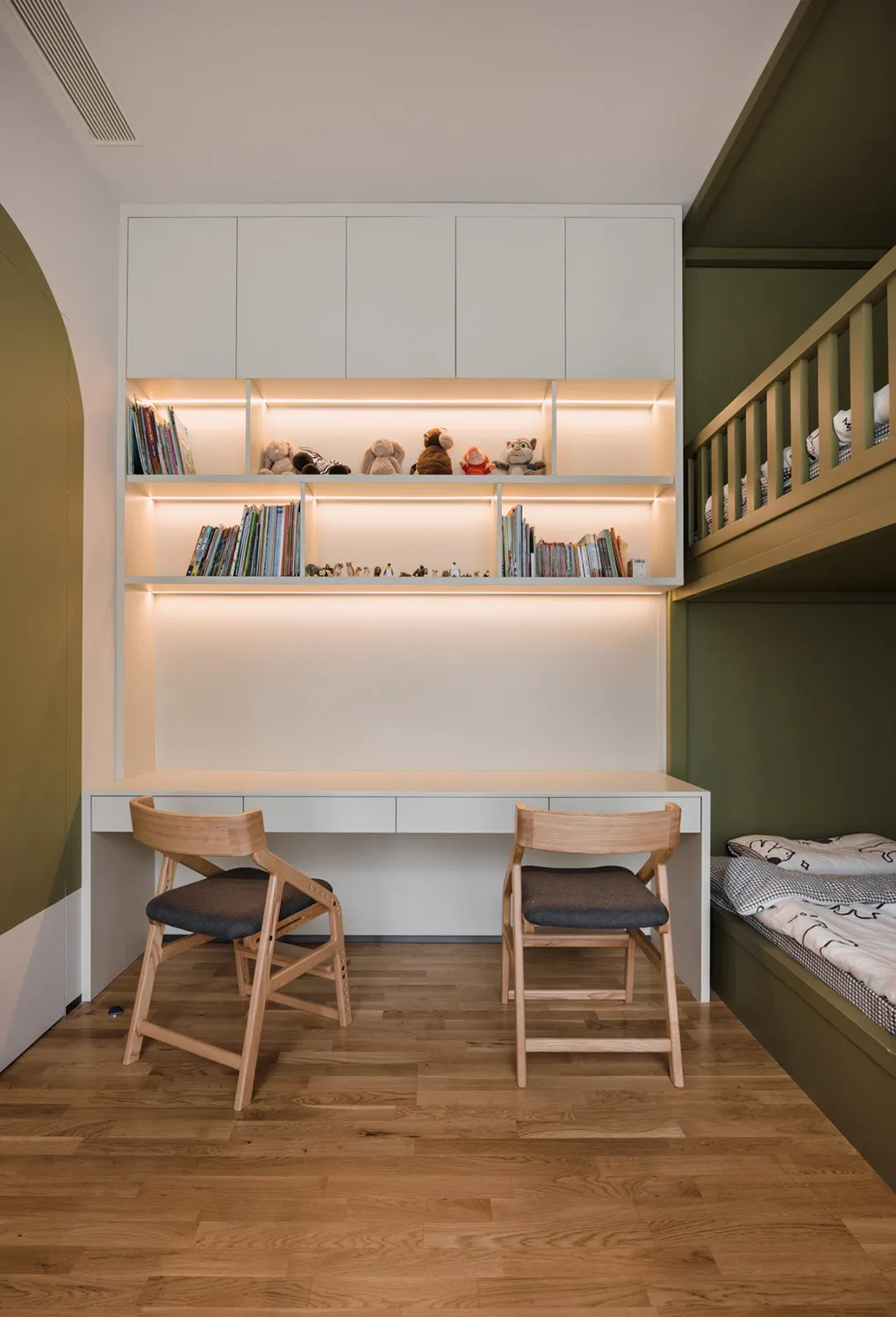 A modern bedroom featuring a wooden desk with integrated storage and shelves.