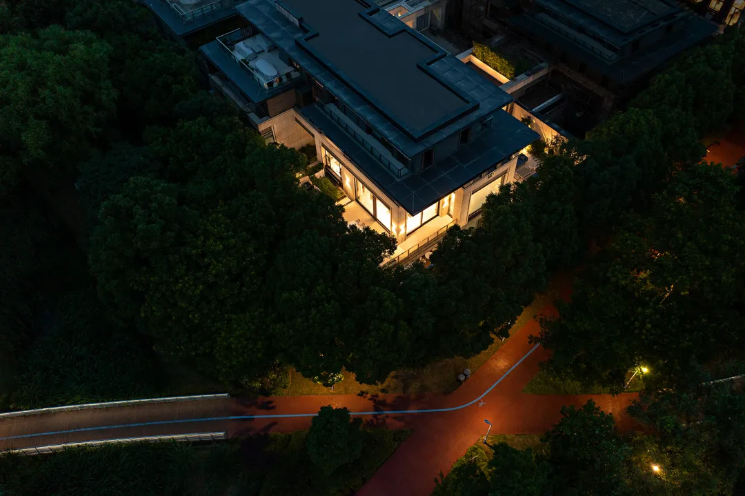 俯瞰現代住宅建築，採用混凝土與玻璃材質，周圍環繞綠意。