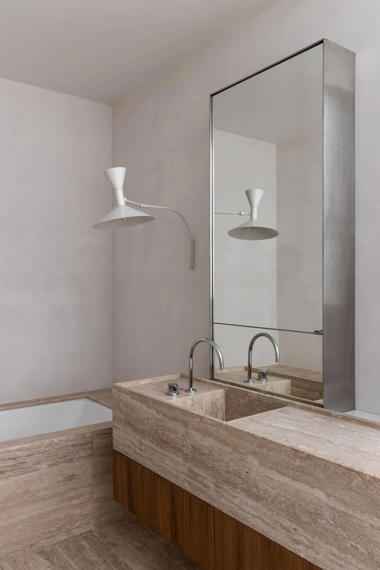 Modern bathroom with a stone countertop and a white bathtub.