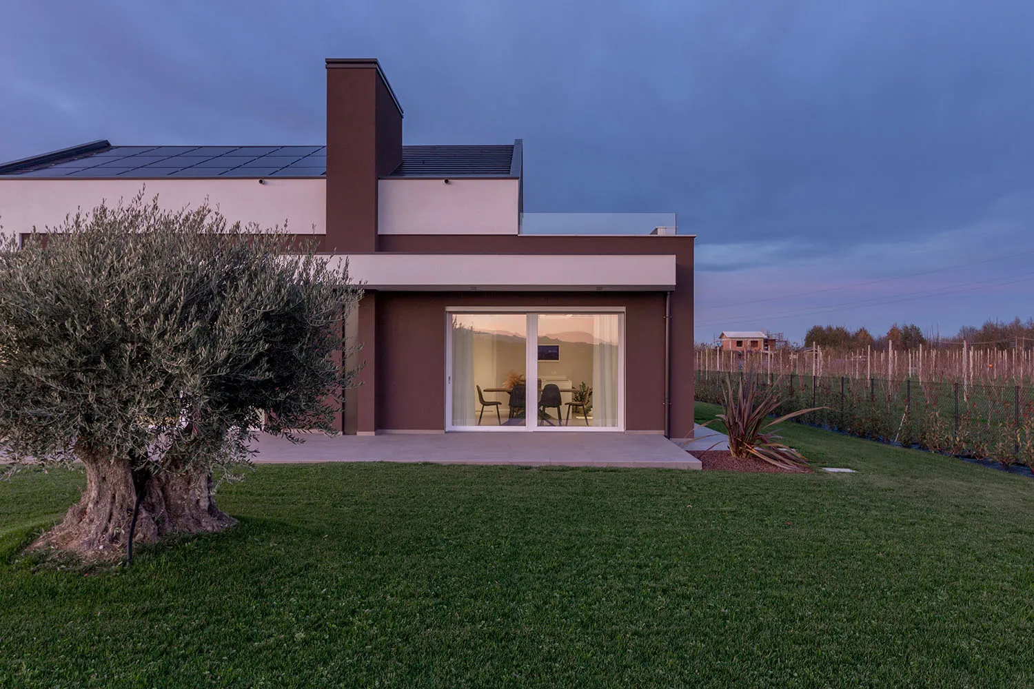 A modern residential exterior with minimalist design, featuring large windows and a sleek, contemporary style.