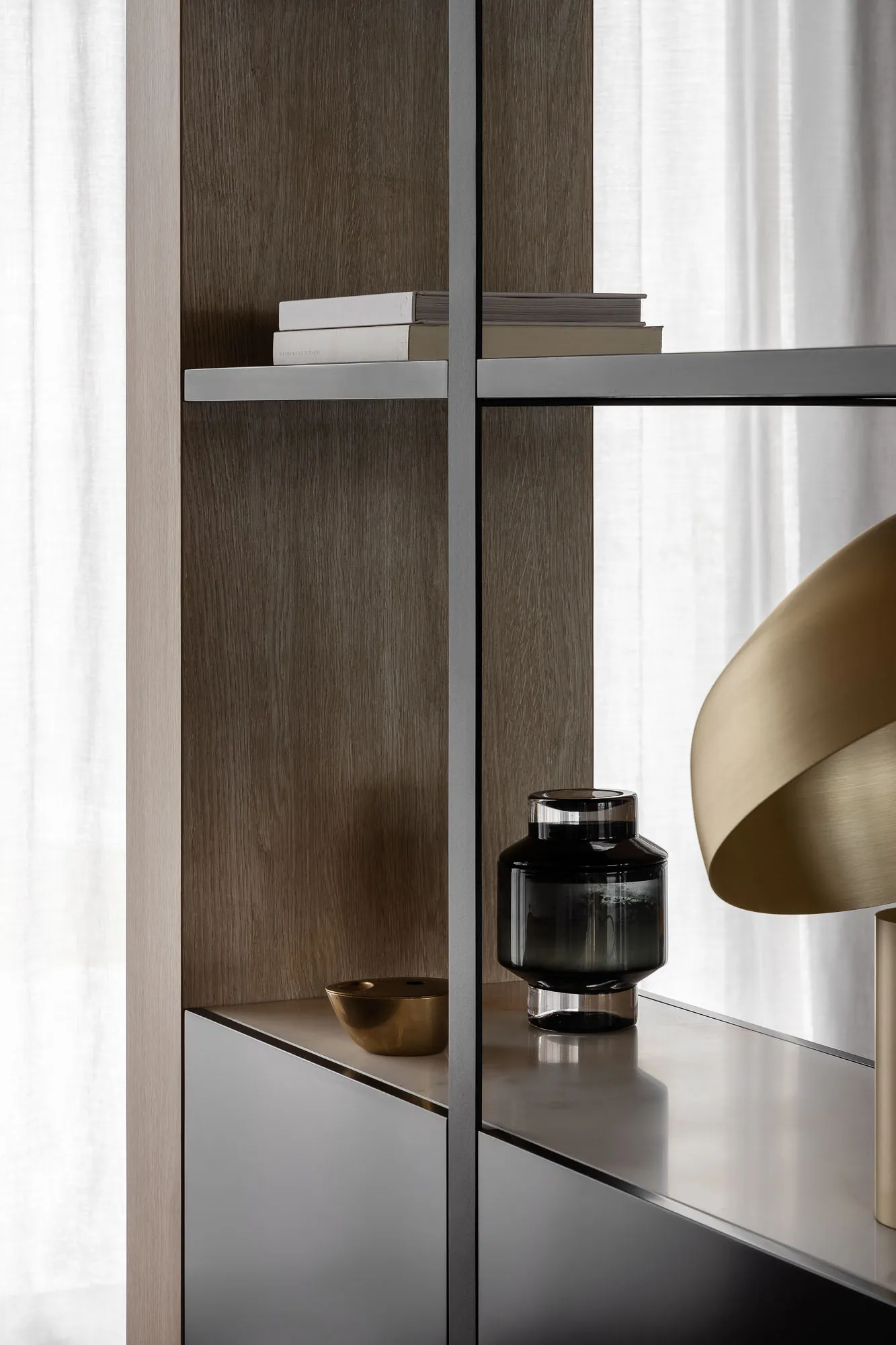 A modern bookshelf with metal and wood shelving and cabinets.