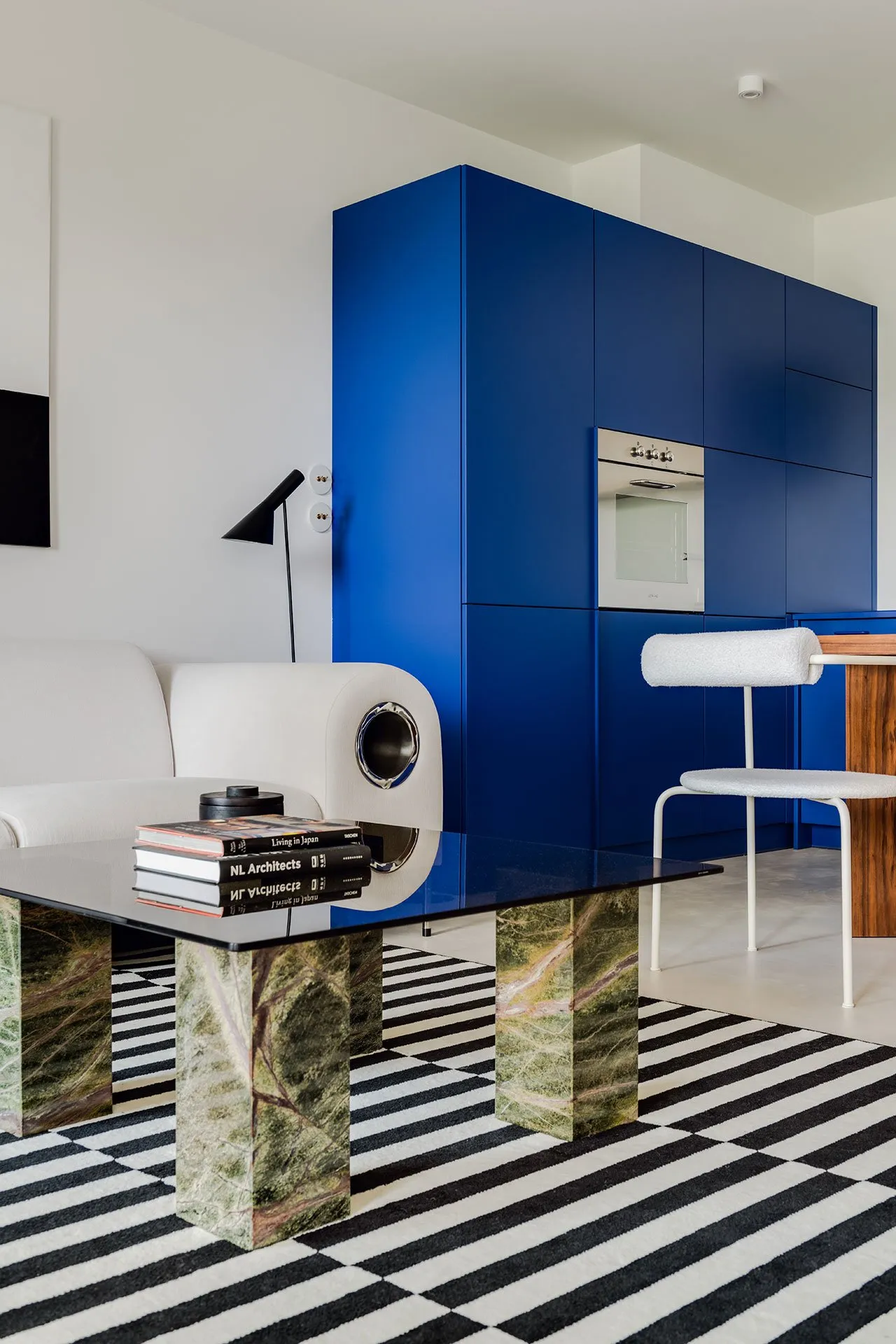 A modern apartment interior featuring minimalist decor with marble coffee table and glass cabinets.