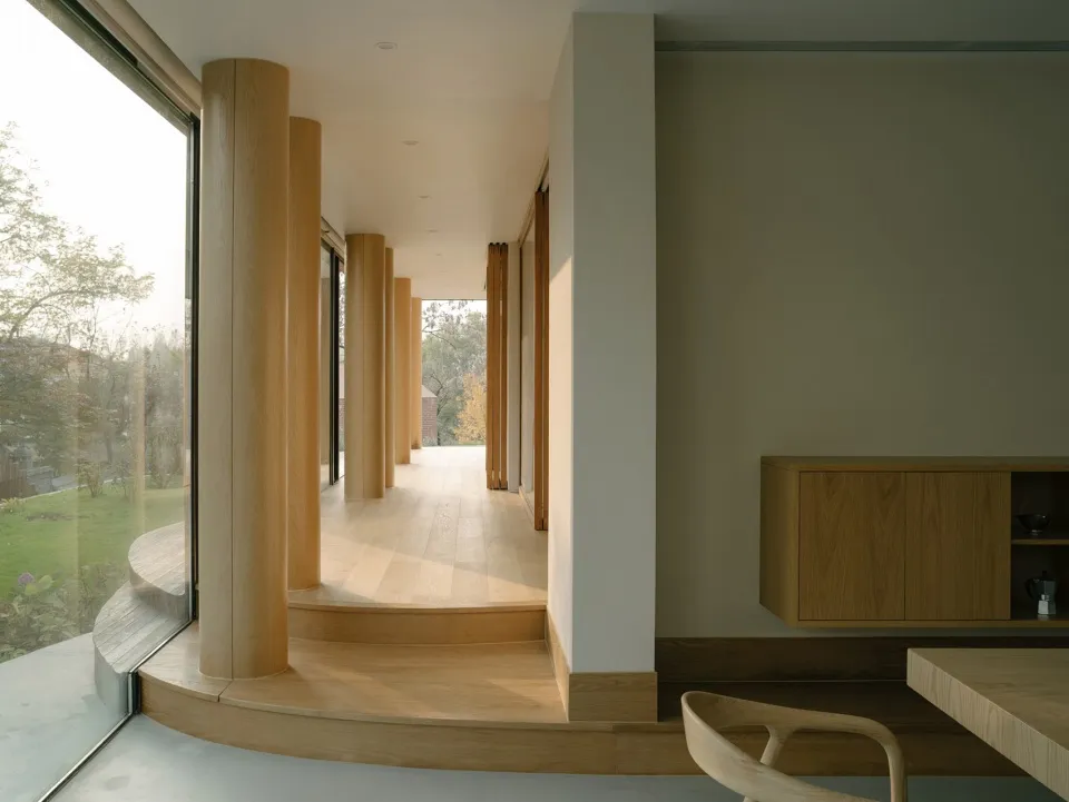Modern interior with wooden columns and light-colored walls.
