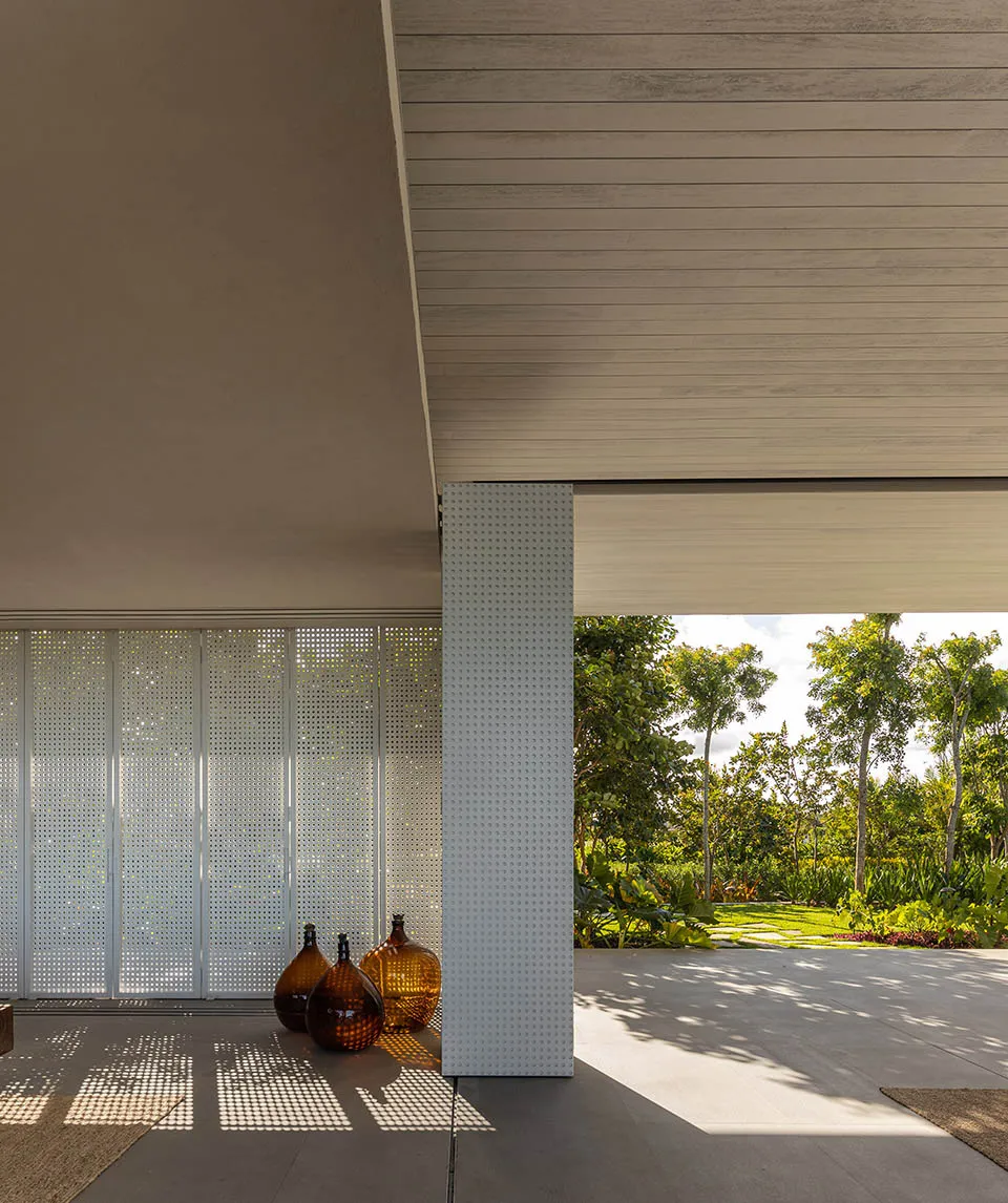 Modern, minimalist house exterior featuring concrete and perforated metal