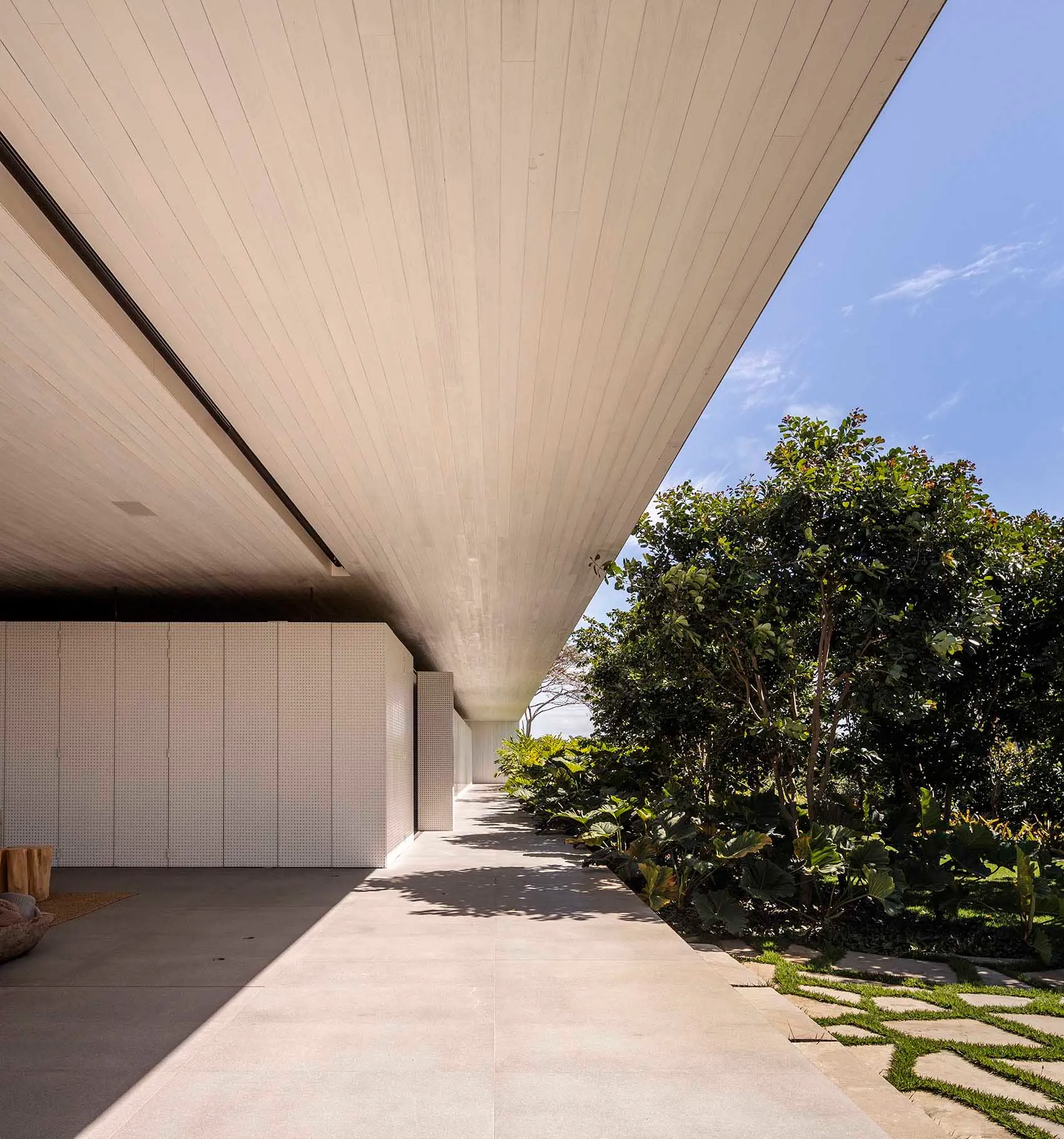 Modern minimalist architectural design featuring a concrete exterior and wooden columns.