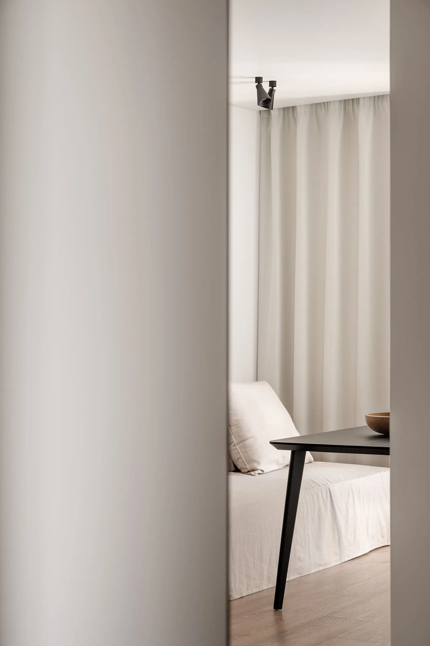 A minimalist interior design with neutral colors and a simple black table.