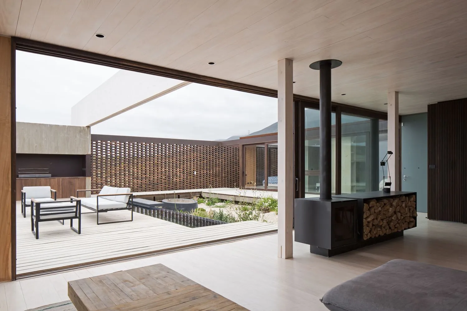 Modern minimalist residential interior featuring wood elements and a garden courtyard.