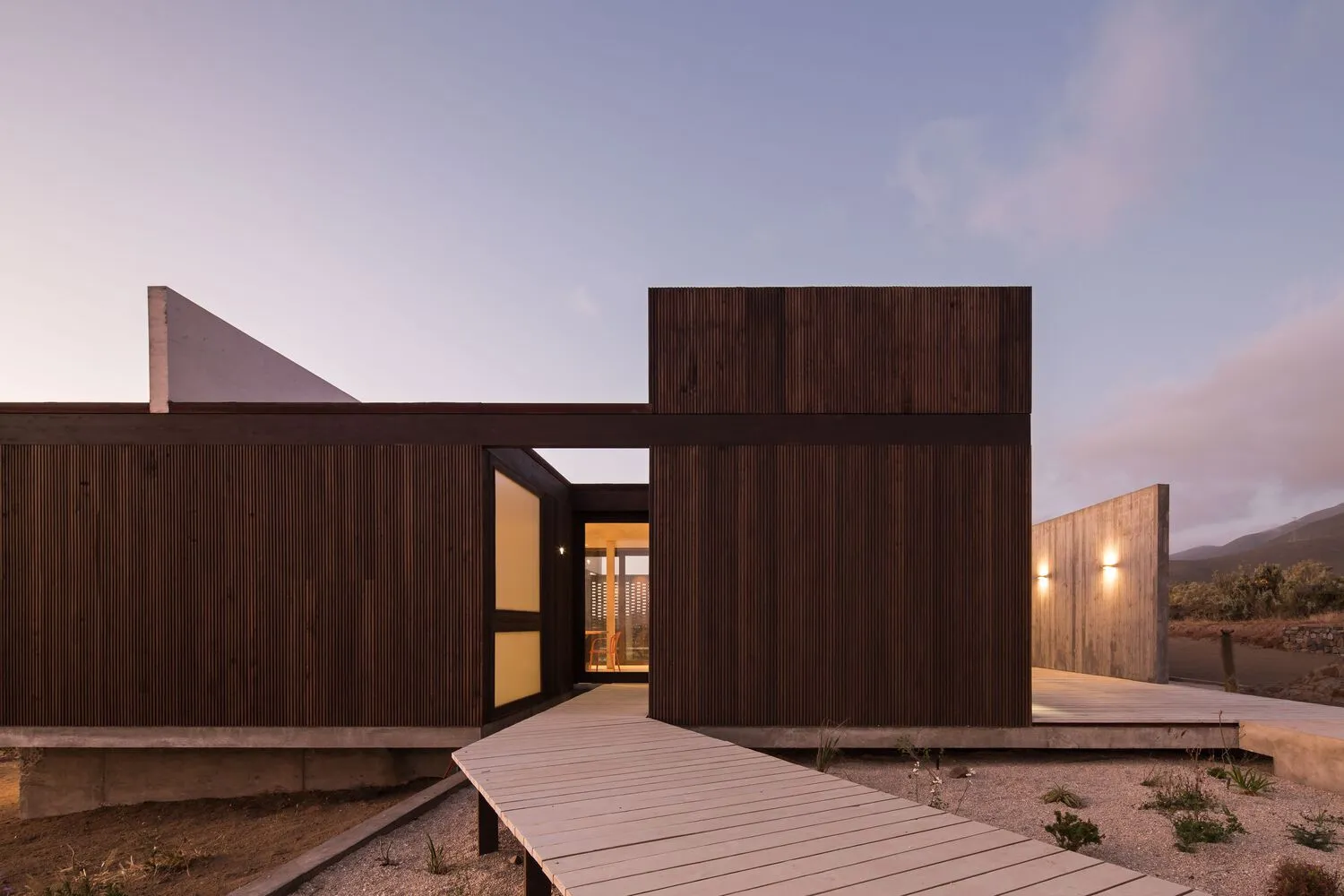 Modern minimalist residential exterior featuring wooden and concrete materials.