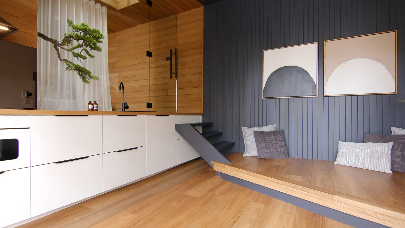 Minimalist residential interior with a modern kitchen and contemporary seating area.