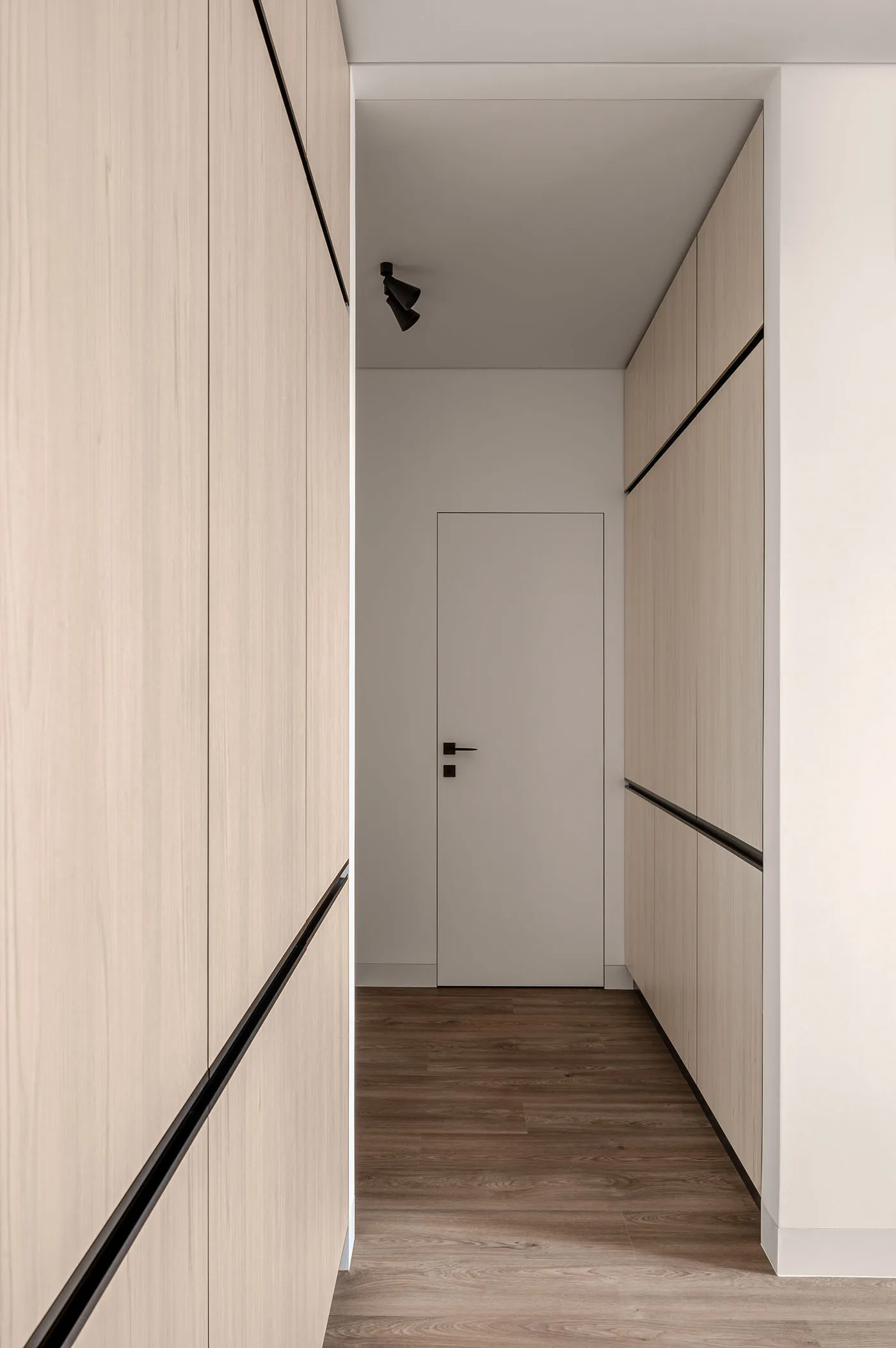 A modern, minimalist interior design corridor featuring wooden panels and sleek, linear accents.