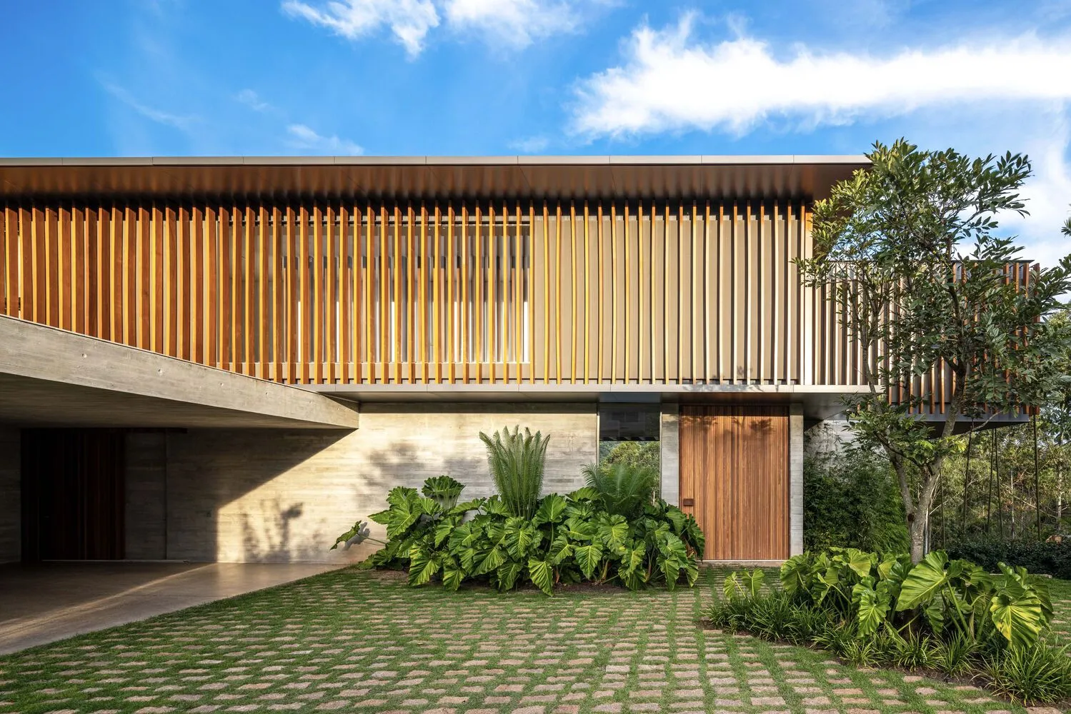 A modern house with wooden exterior and a clear blue sky.
