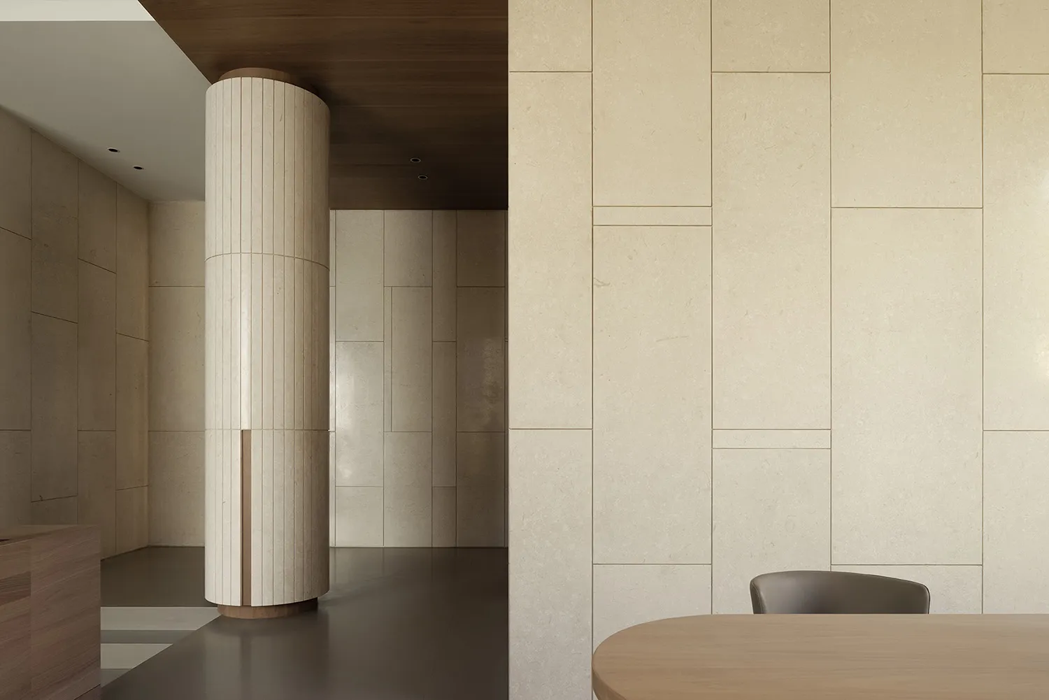 A minimalist office space featuring a natural stone wall and floor.
