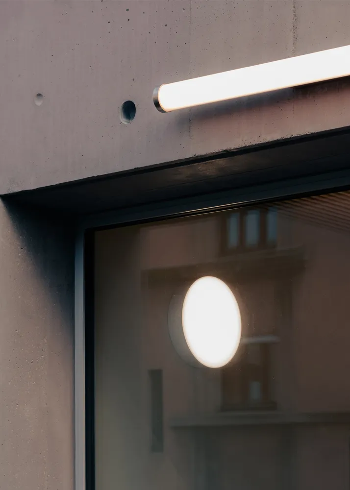 Modern, minimalist doorway with glass panels and a textured, industrial wall.