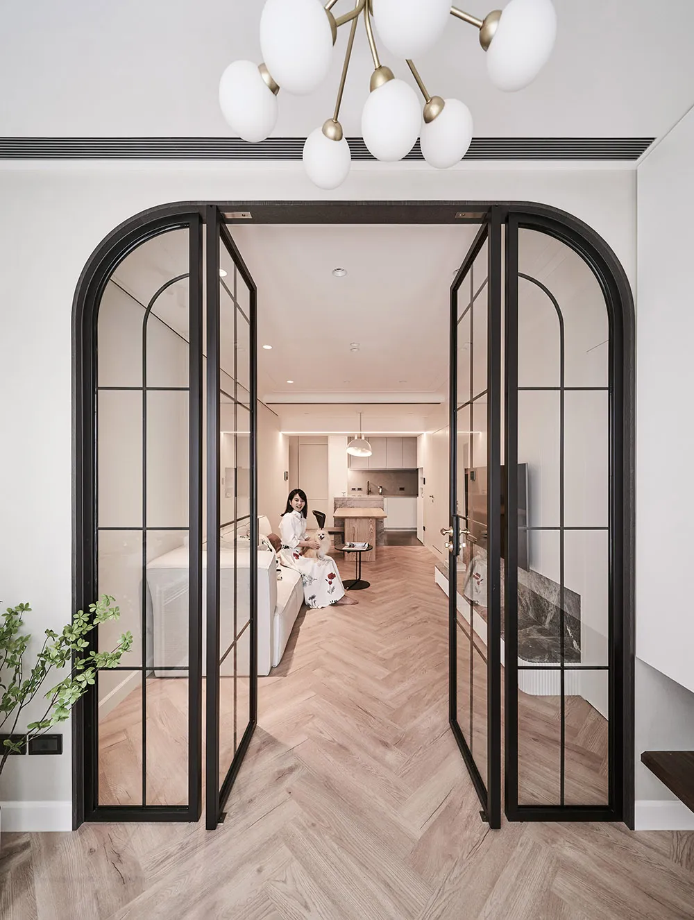 A minimalist living room with wooden furniture and glass doors.