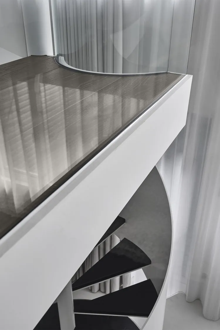 Modern, black staircase featuring glass railings