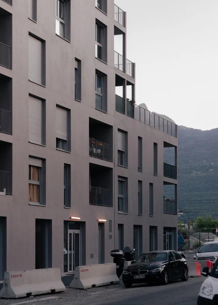 Modern apartment building with concrete exterior and balconies.