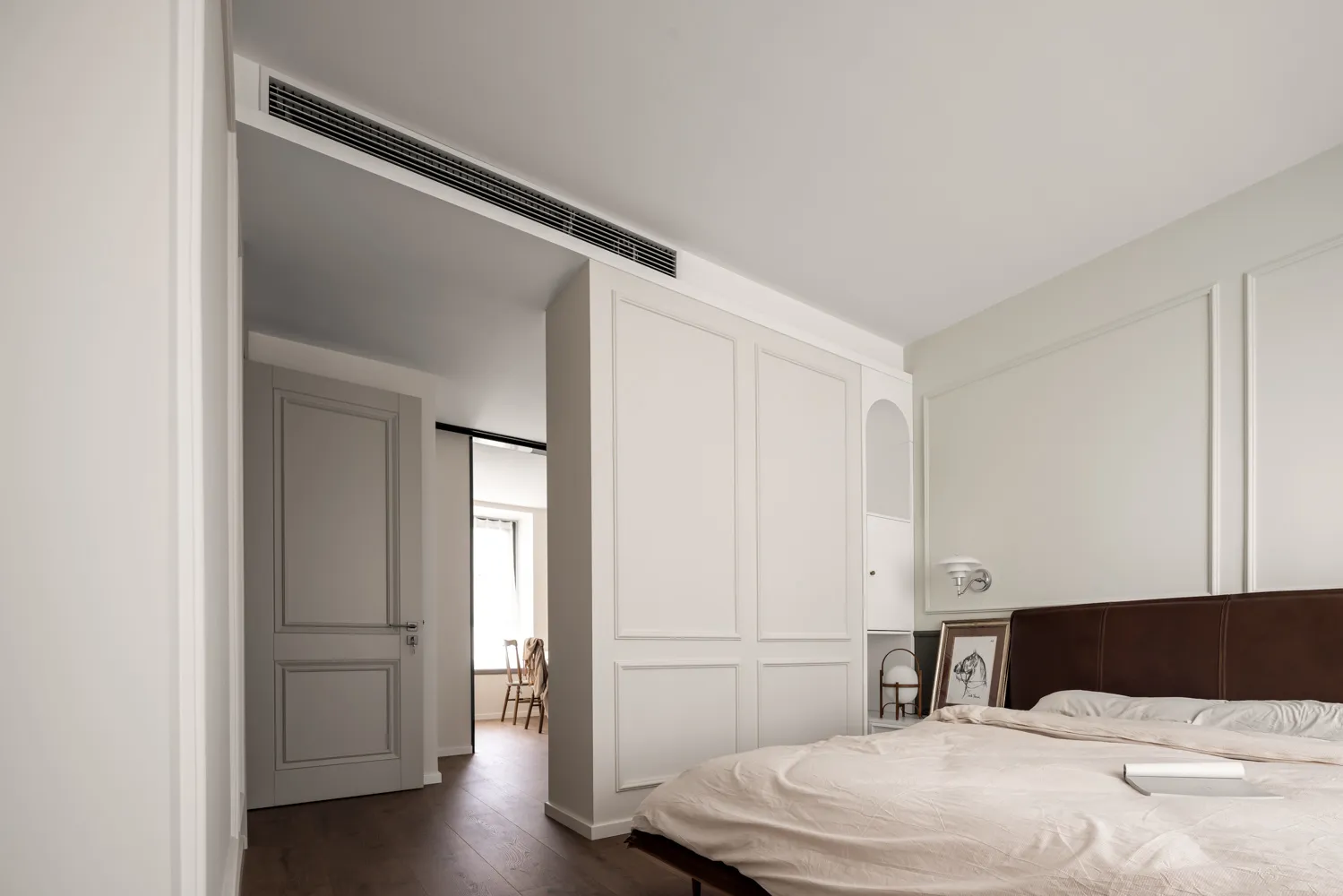 Minimalist bedroom with modern white furniture and materials.