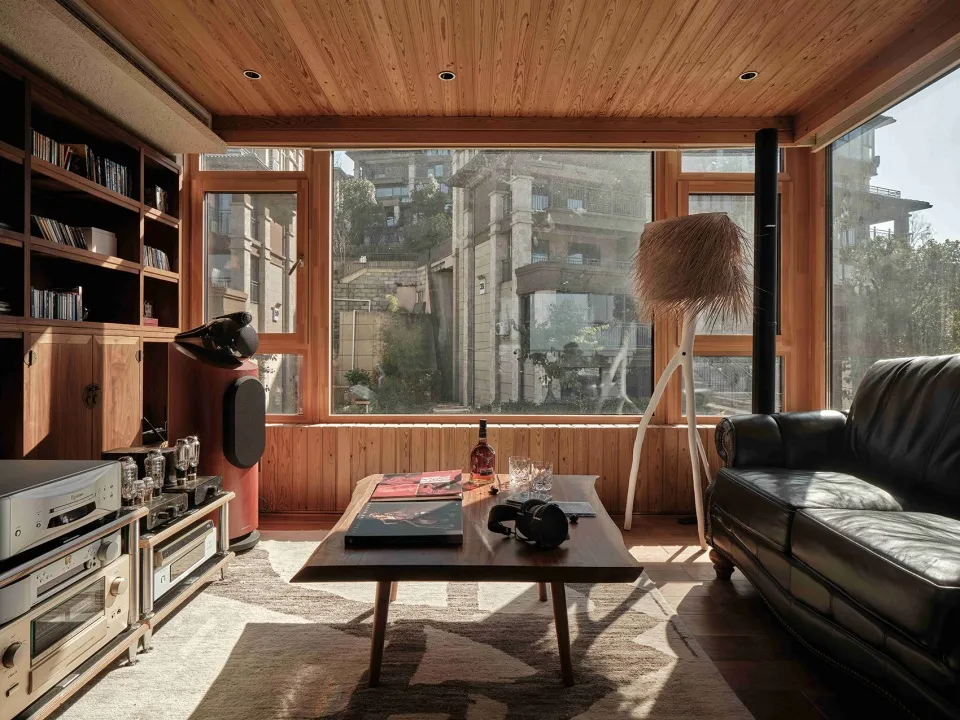 A modern living room with wood features and large windows showing a city view.