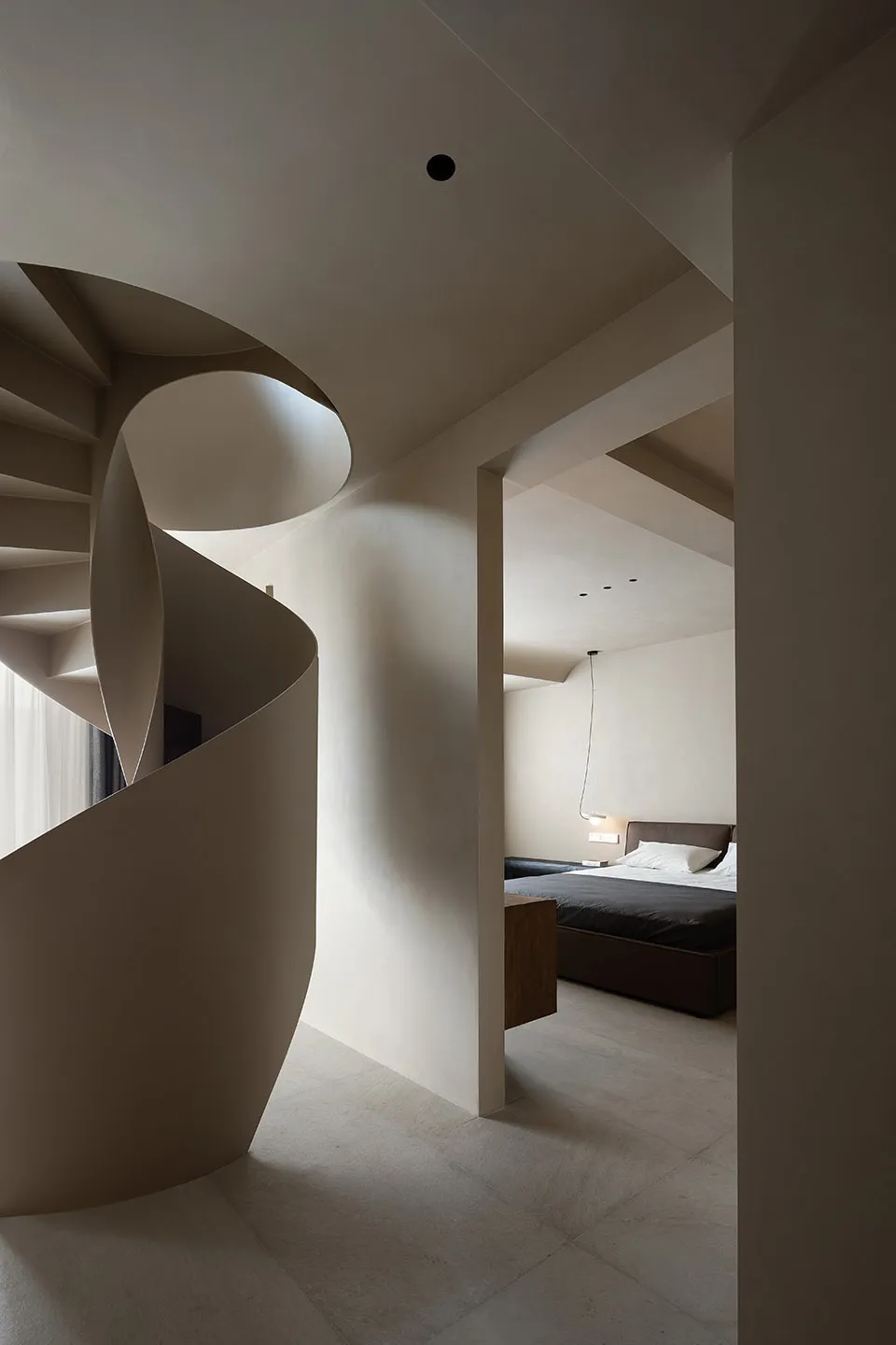 Modern residential interior featuring a spiral staircase made of concrete and wooden walls.