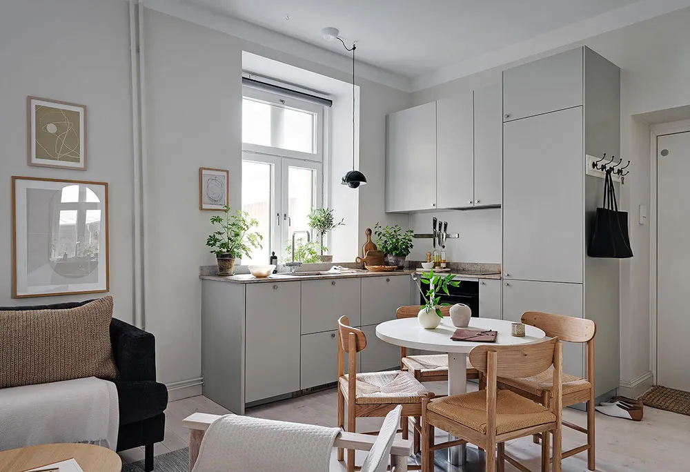 Modern minimalistic living and dining space featuring wooden furniture, metal accents, and concrete surfaces