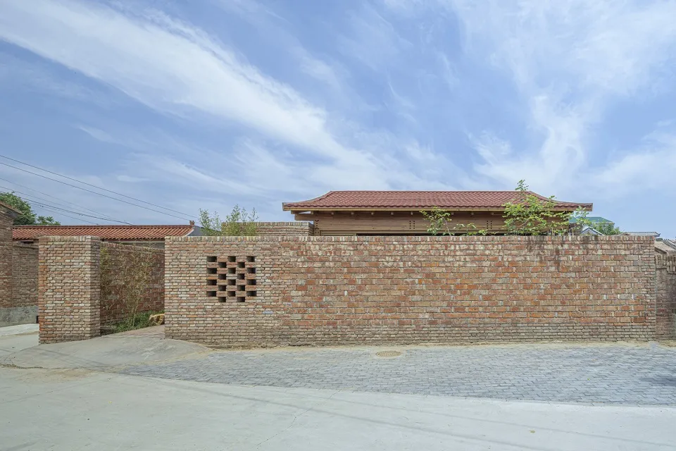 A traditional building with a white roof and brick walls and windows.