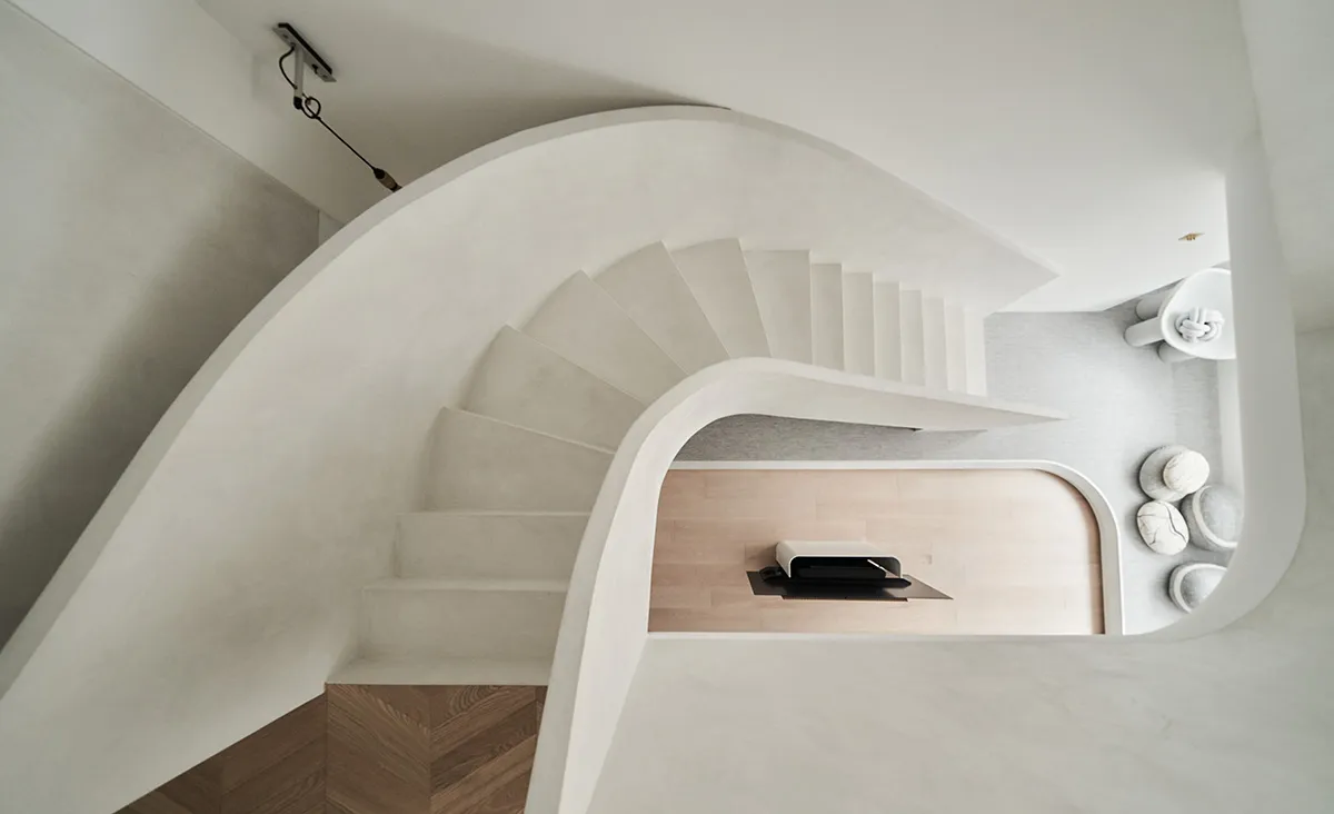 A modern white concrete staircase with smooth rounded edges.
