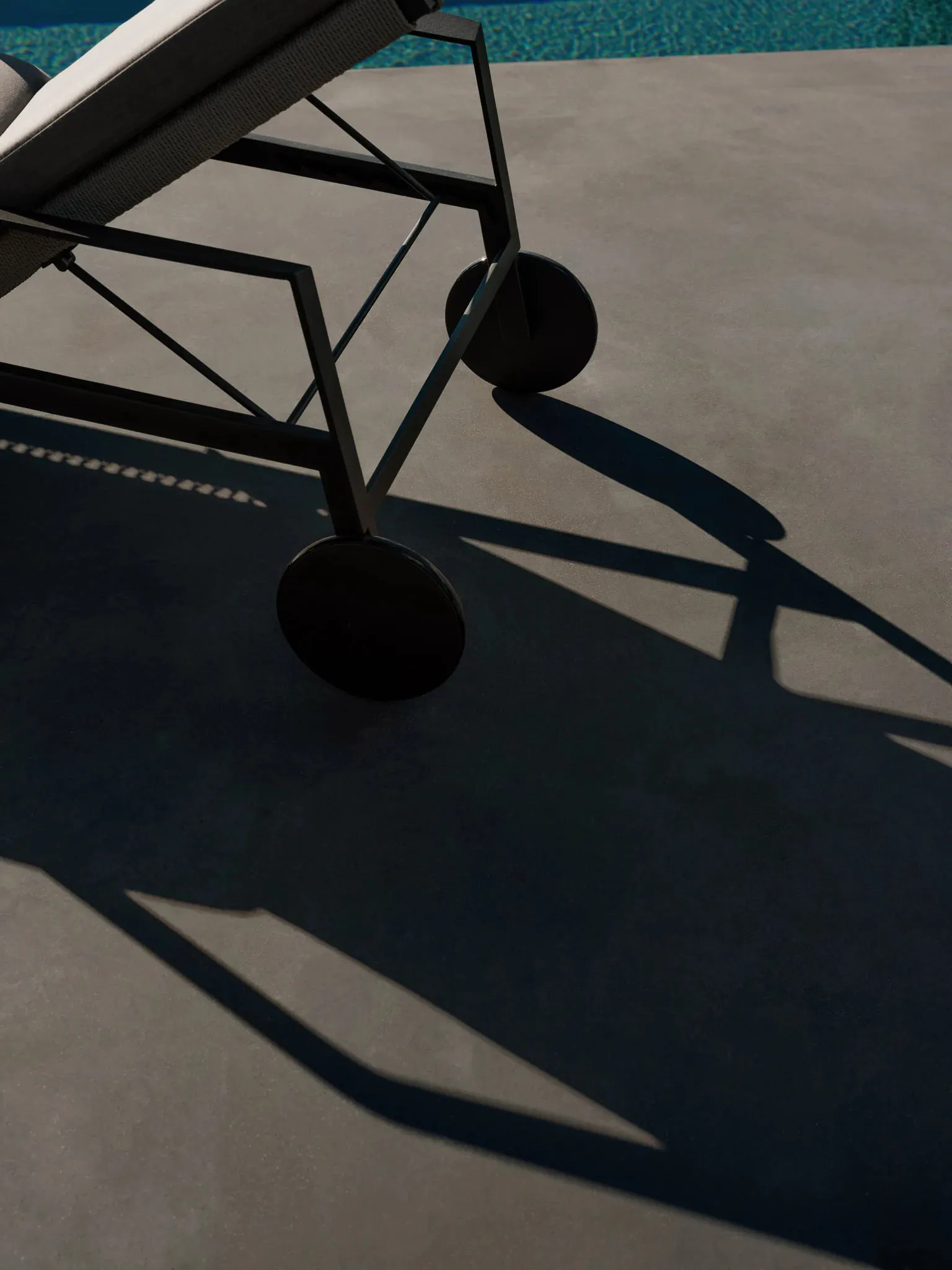 A minimalist outdoor lounge chair in matte black metal design.