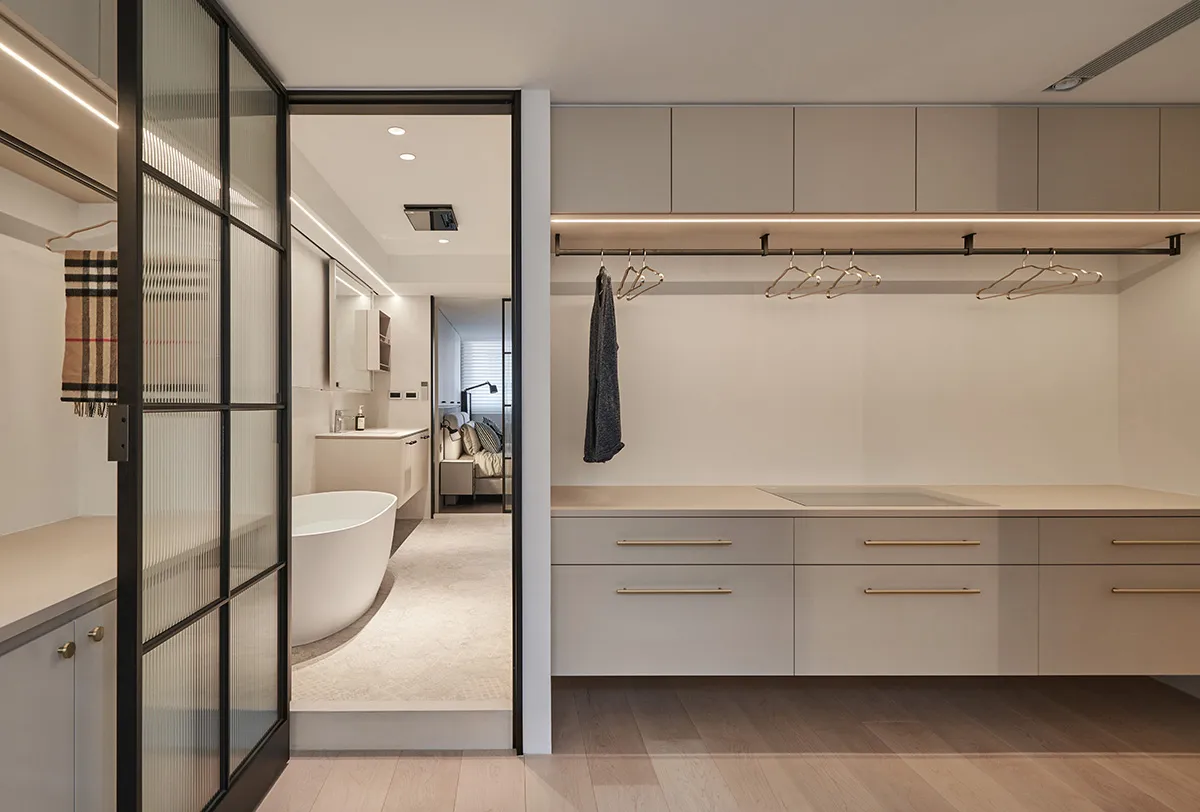 Modern minimalist closet featuring a neutral-toned color palette with natural materials, including a hanging rail for clothes